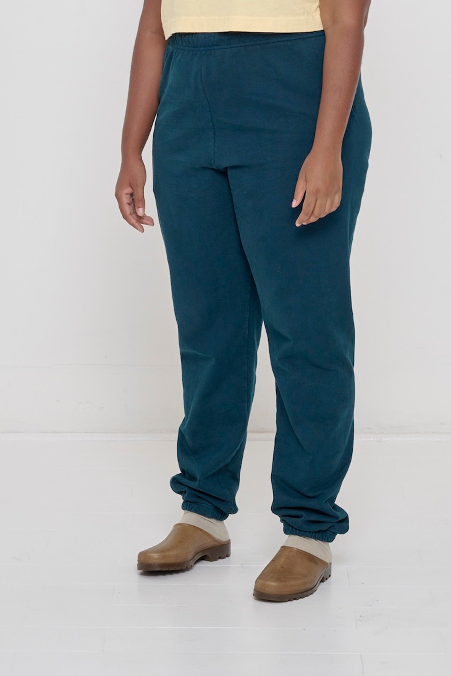 Person turned 45 degrees, wearing Juniper Trash Sweatpants, showing inseam and top of the side pockets.