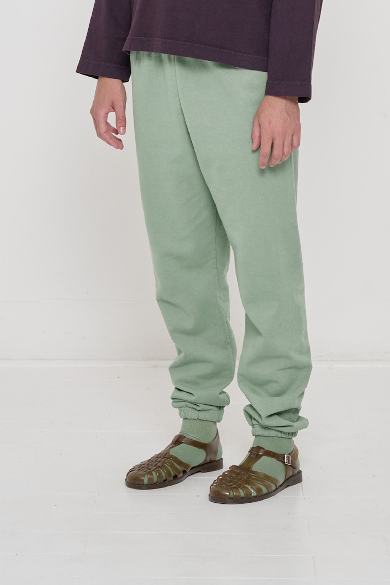 Person turned 45 degrees, wearing Wasabi Trash Sweatpants, showing inseam and top of the side pockets.