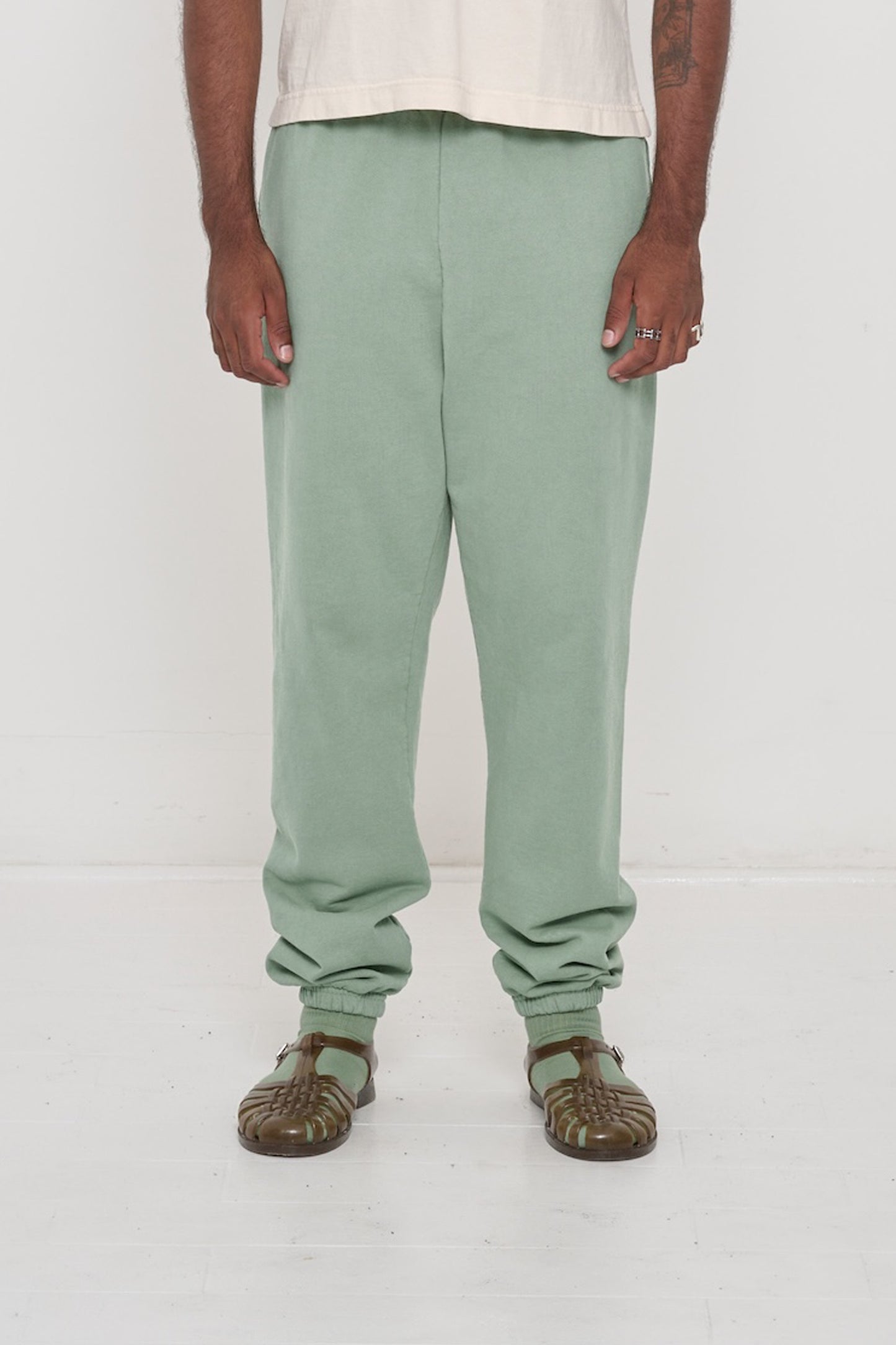 Front view of a person in Wasabi Trash Sweatpants, relaxed fit, mild slouchy bunching at ankles.