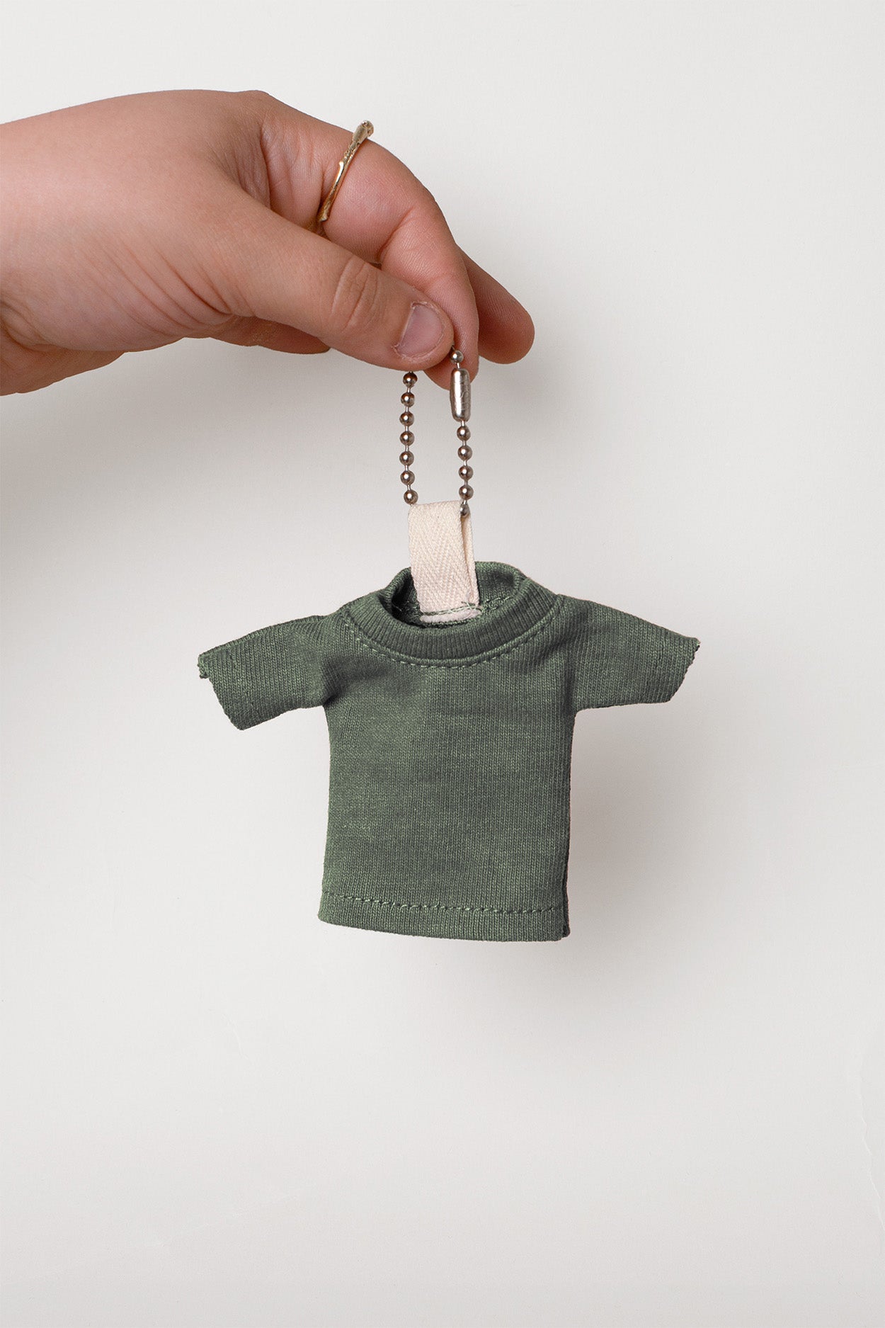 Pine T-shirt keychain held by a hand