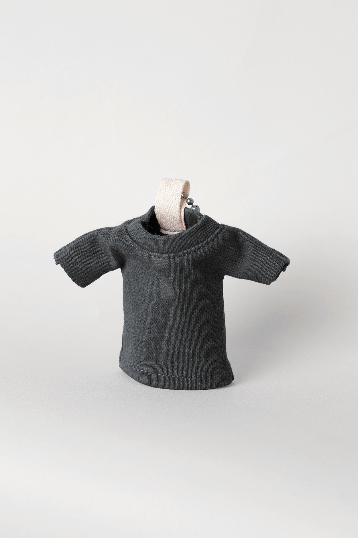 Slate T-shirt keychain, propped up, against a light gray background