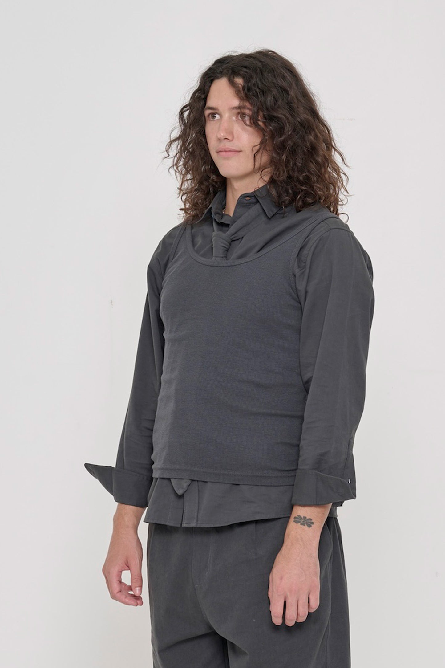 3/4 view of a person wearing Slate Trash Tie tucked into Slate Rib Tank over Slate Button-Up Shirt.