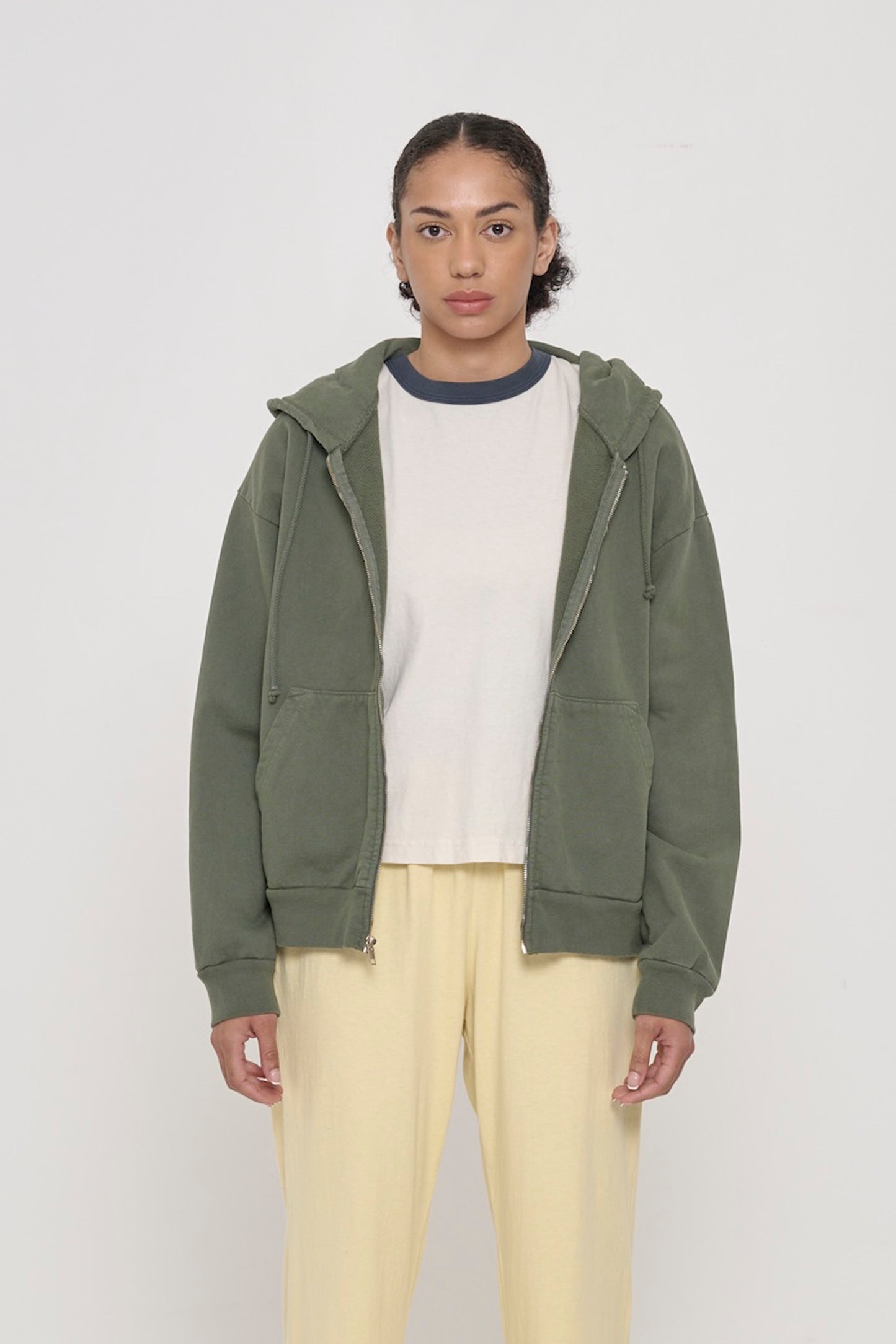 Front view of a person wearing Pine Trash Zip Up Hoodie. Hem hits mid hip.