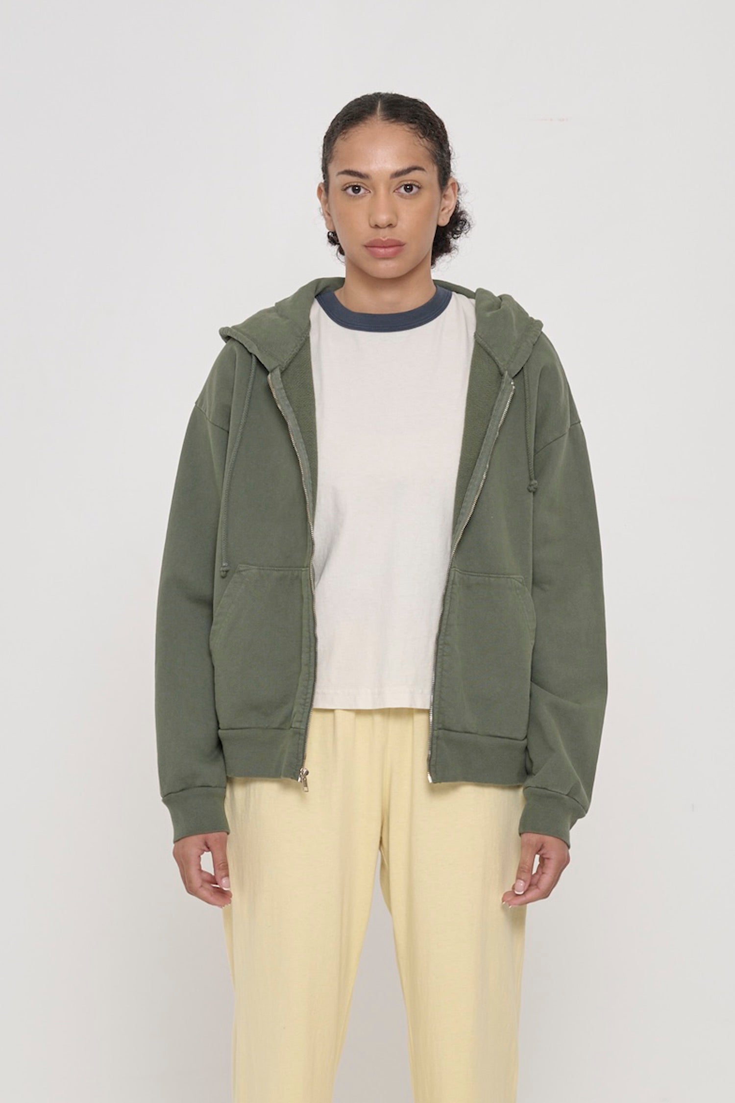 Front view of a person wearing Pine Trash Zip Up Hoodie. Hem hits mid hip.