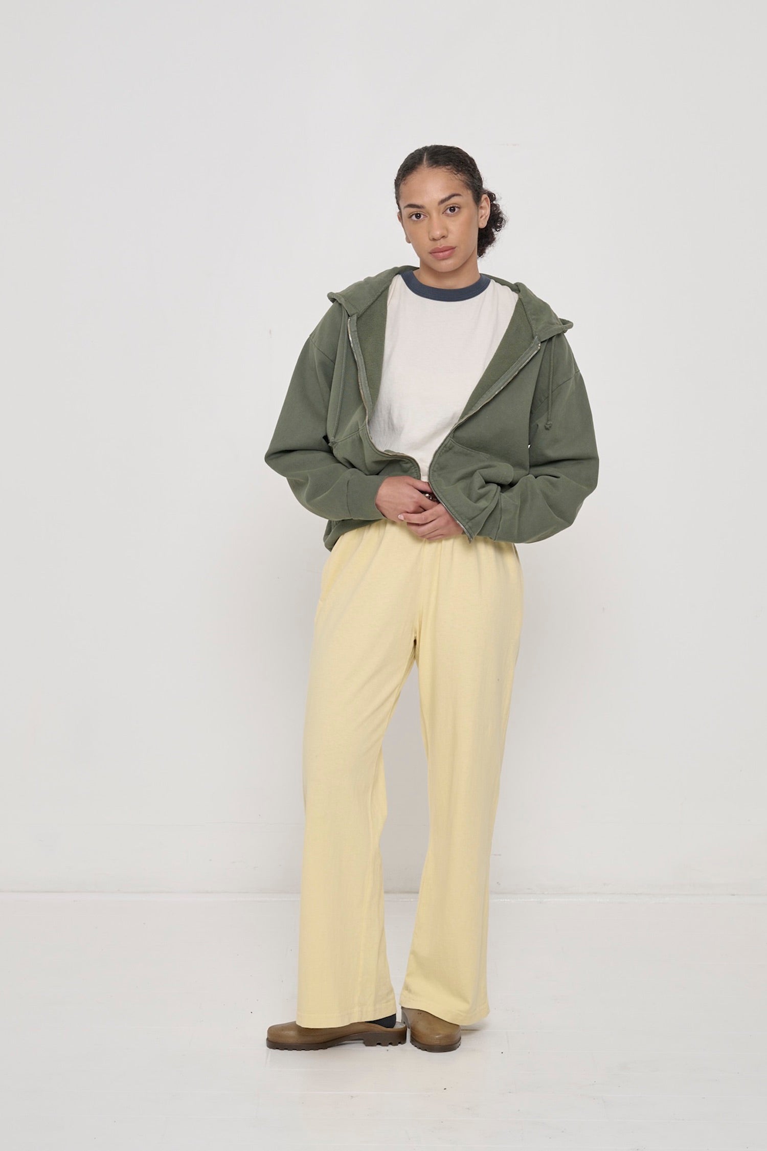 Person wearing Pine Trash Zip Up Hoodie with French Butter Apartment Pants and Slate Ringer Trash Tee.