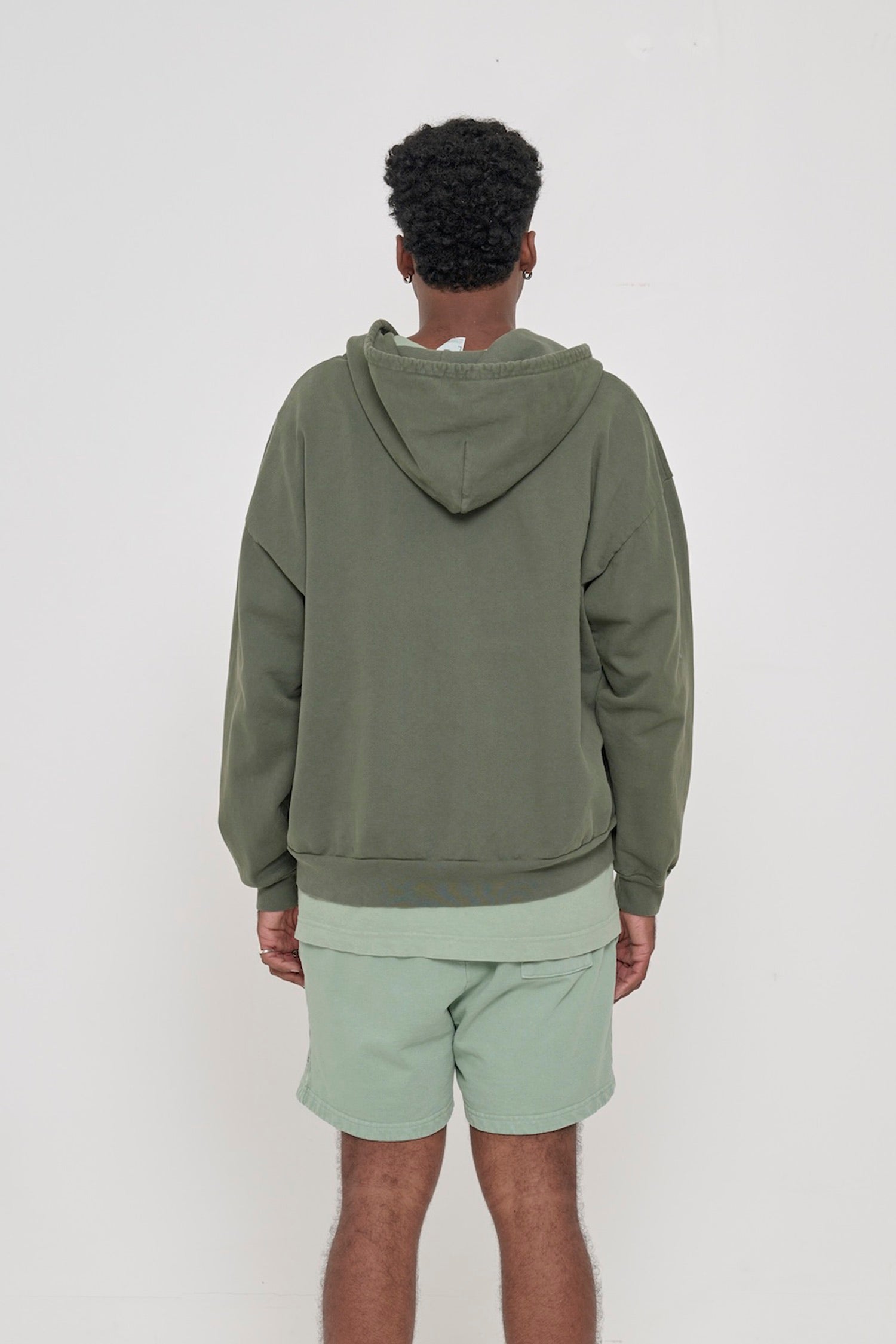 Back view of a person wearing a Pine Trash Zip Up Hoodie, highlighting the hood.