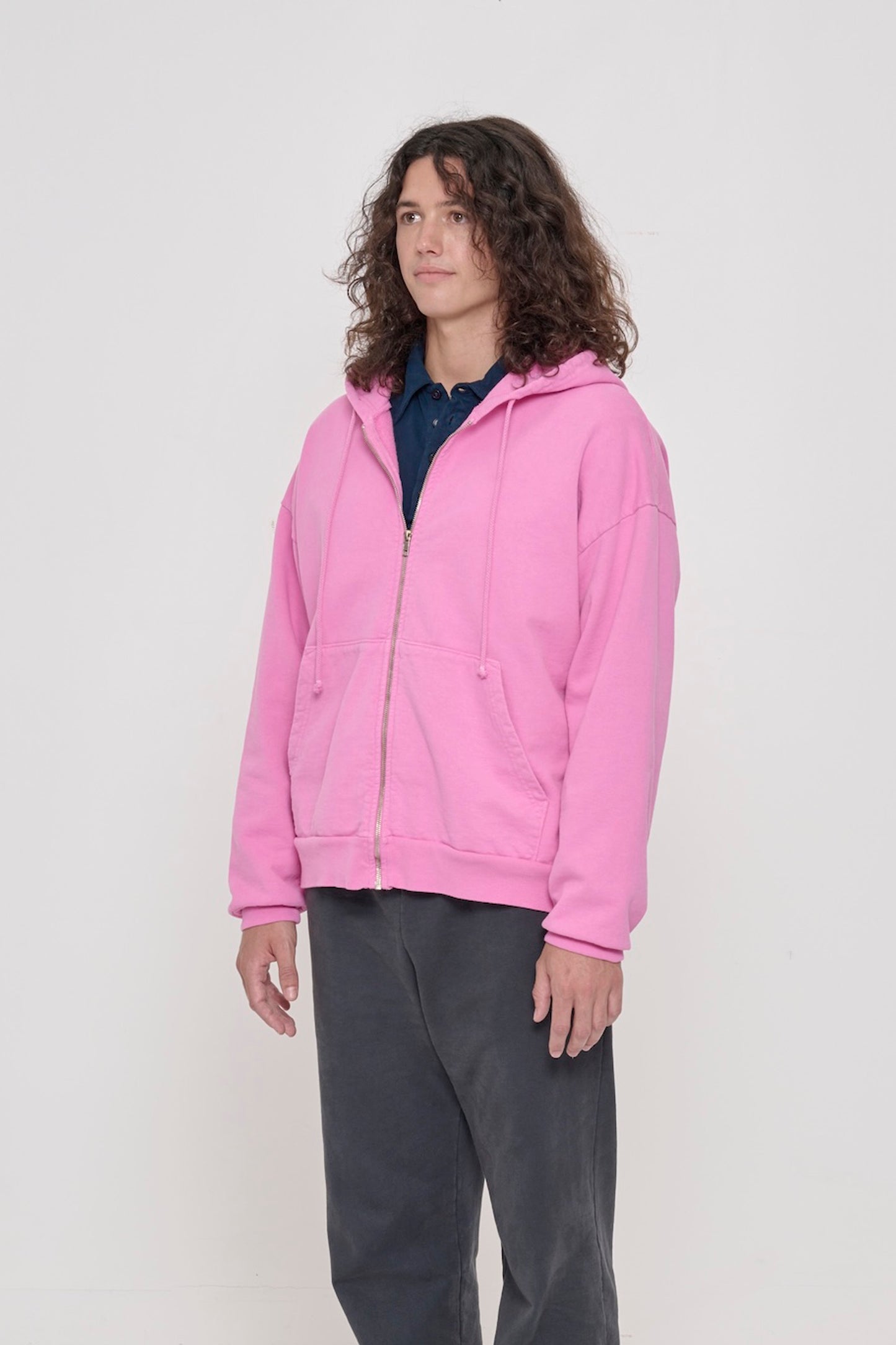 Person facing 45-degrees, wearing a Pixie Trash Zip Up Hoodie, showcasing sleeve's relaxed fit and drop shoulder.