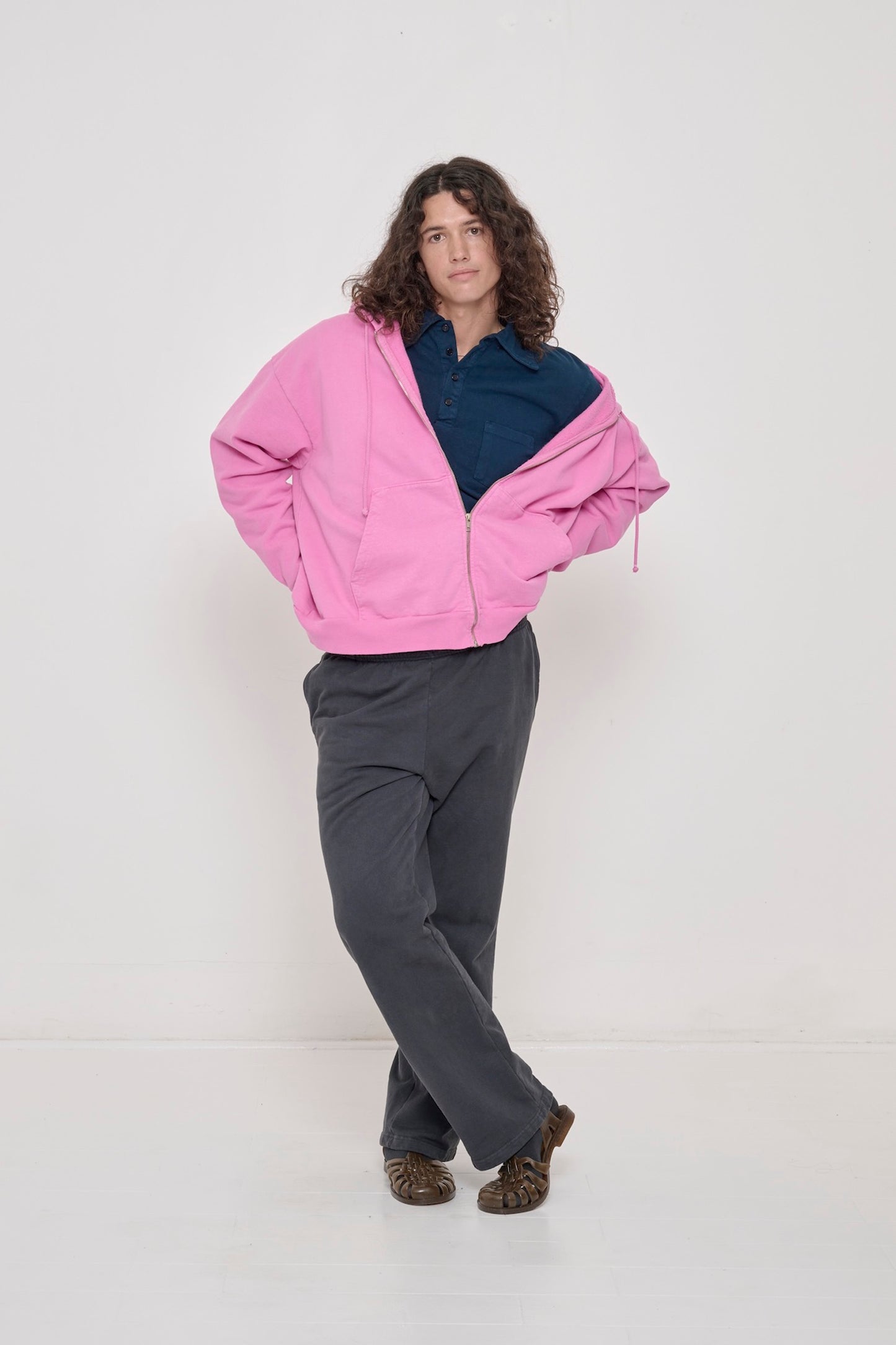 Person wearing half zipped Pixie Trash Zip Up Hoodie slouched off one shoulder with Juniper Rugby Trash Polo under. 