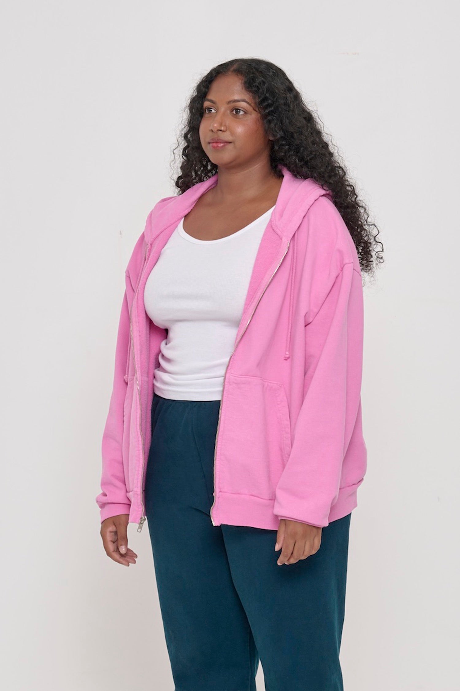 Person facing 45-degrees, wearing a Pixie Trash Zip Up Hoodie, showcasing sleeve's relaxed fit and drop shoulder.
