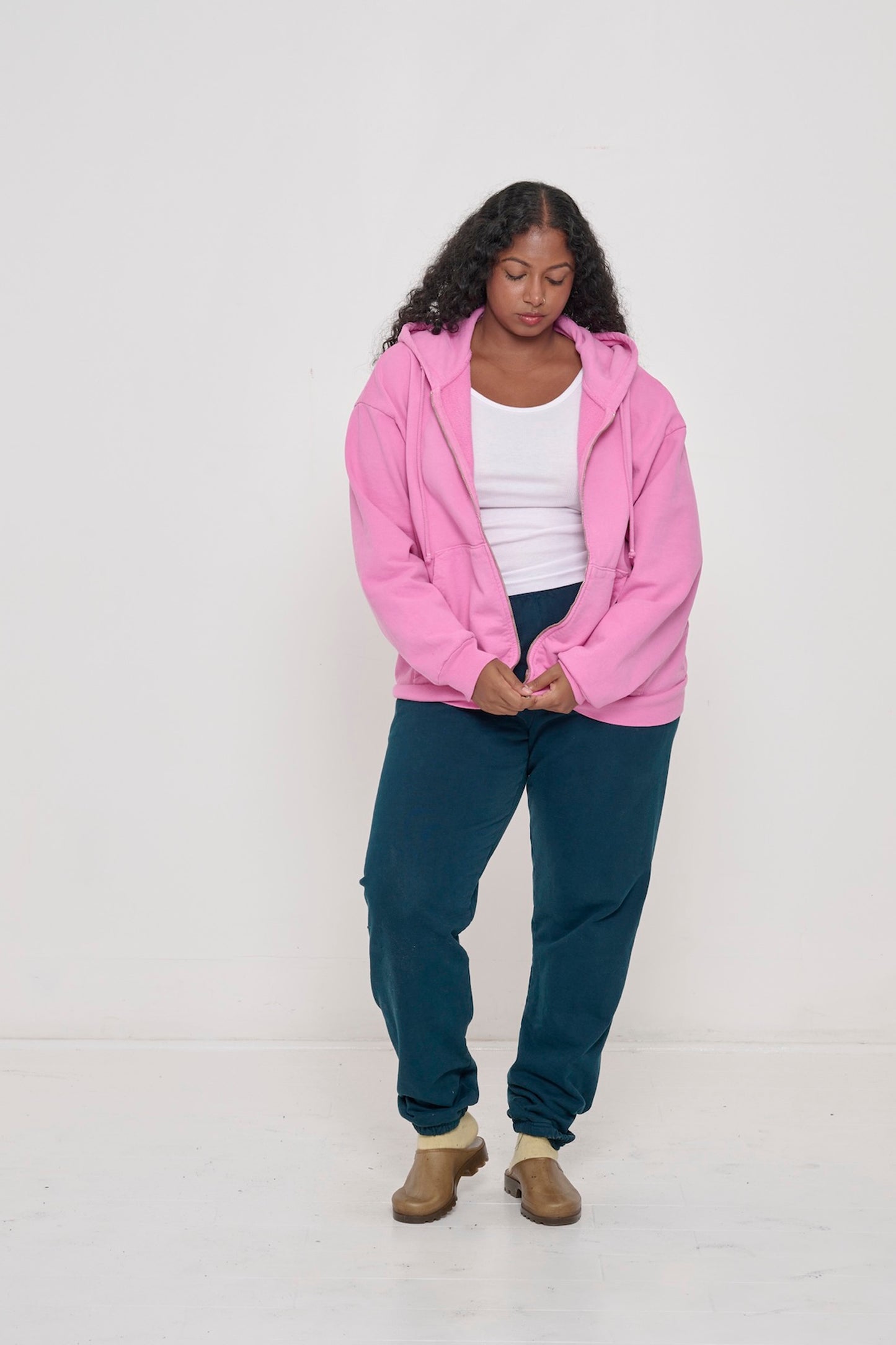 Person zipping up Pixie Trash Zip Up Hoodie with Juniper Trash Sweatpants and White Rib Tank. 