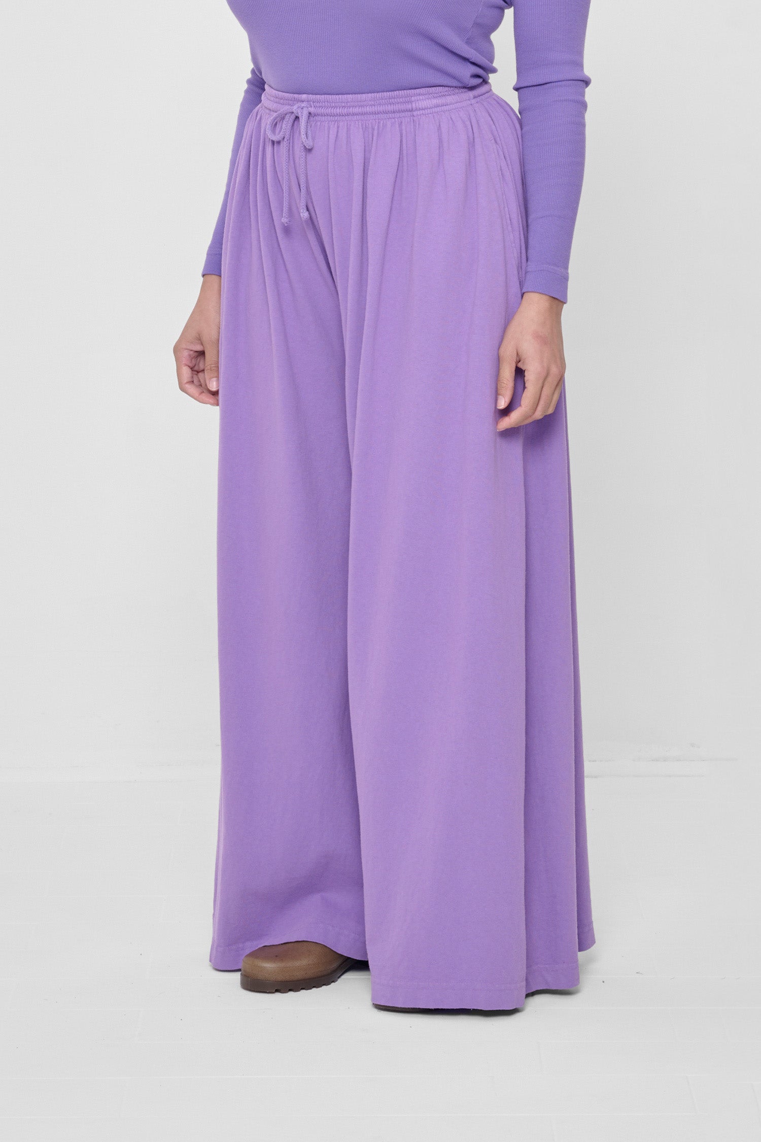 Person facing 45-degrees from the front, showing lack of side seams and flowing wide pant legs.