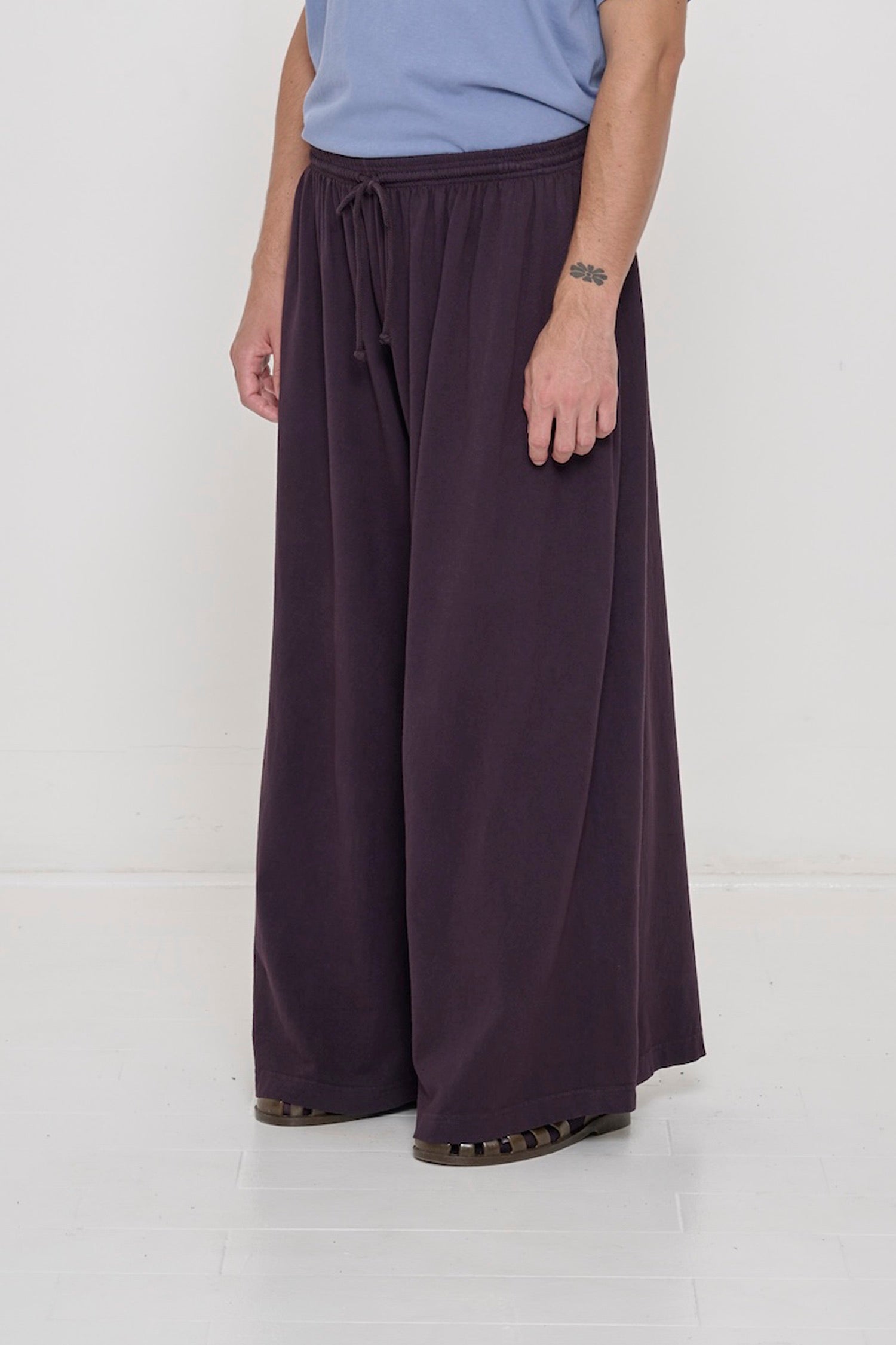 Person facing 45-degrees to the front in Mulberry Tubular Pants, showing lack of side seams and flowing wide pant legs.