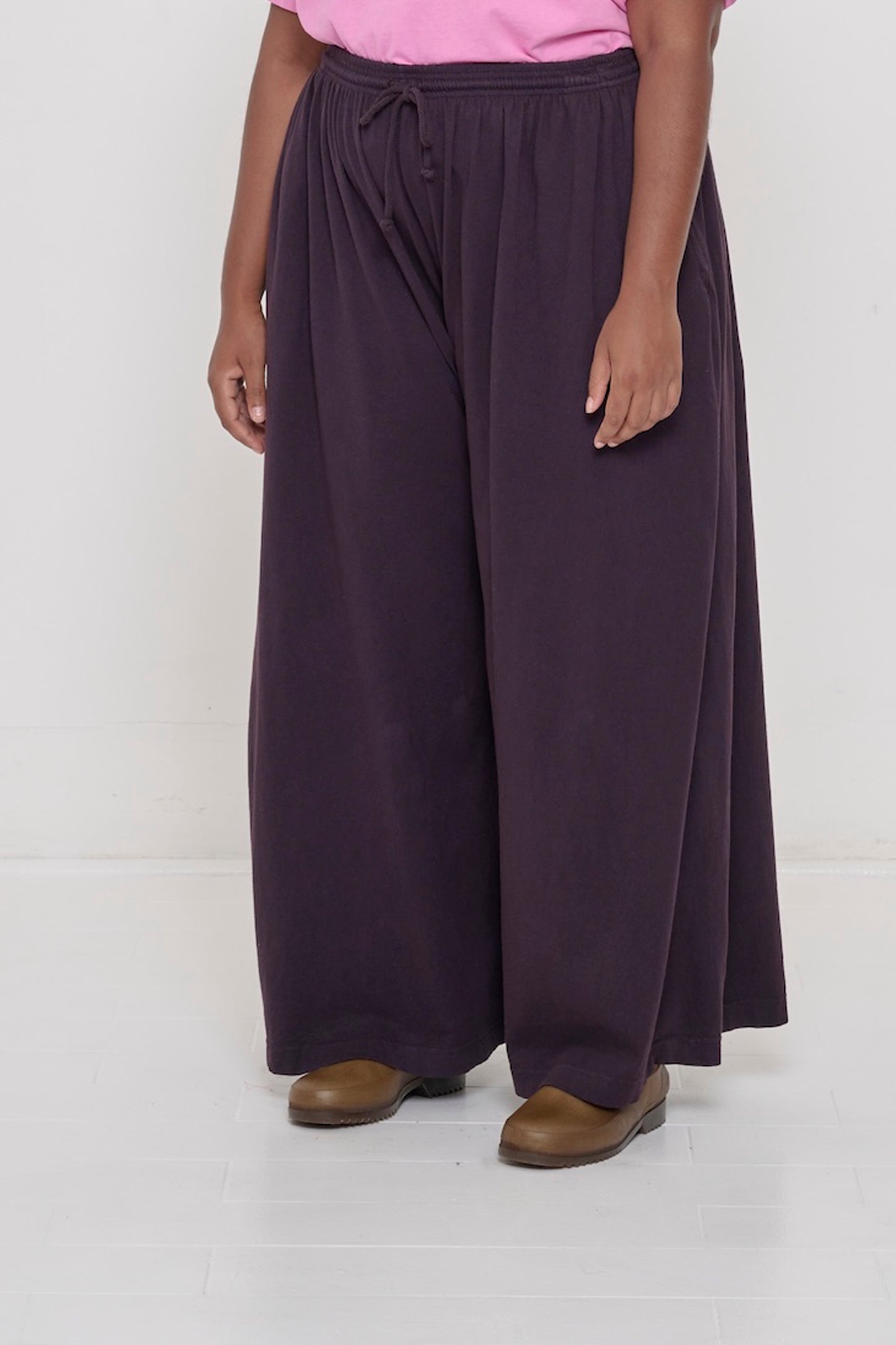 Person facing 45-degrees to the front in Mulberry Tubular Pants, showing lack of side seams and flowing wide pant legs.