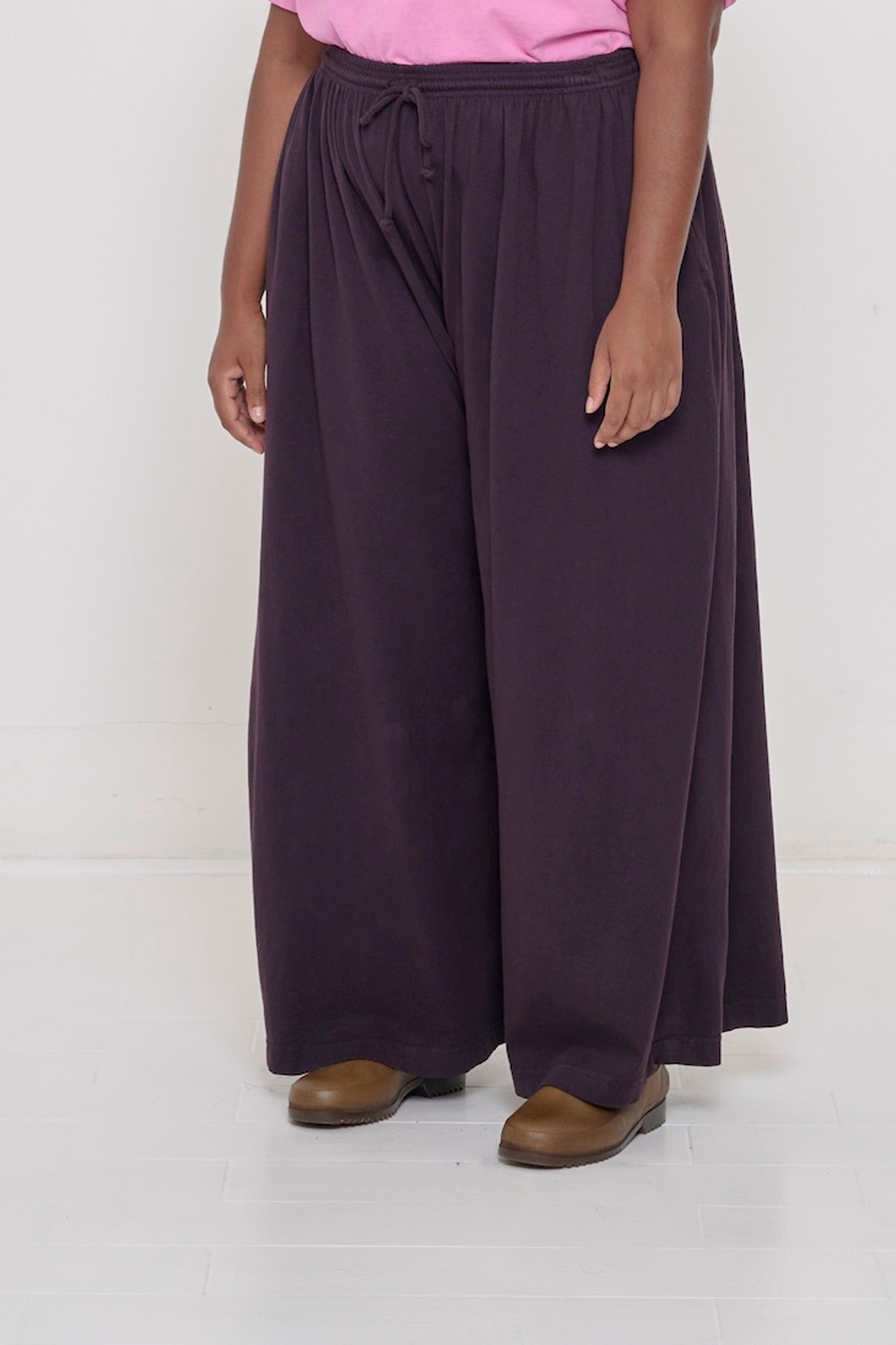 Person facing 45-degrees to the front in Mulberry Tubular Pants, showing lack of side seams and flowing wide pant legs.