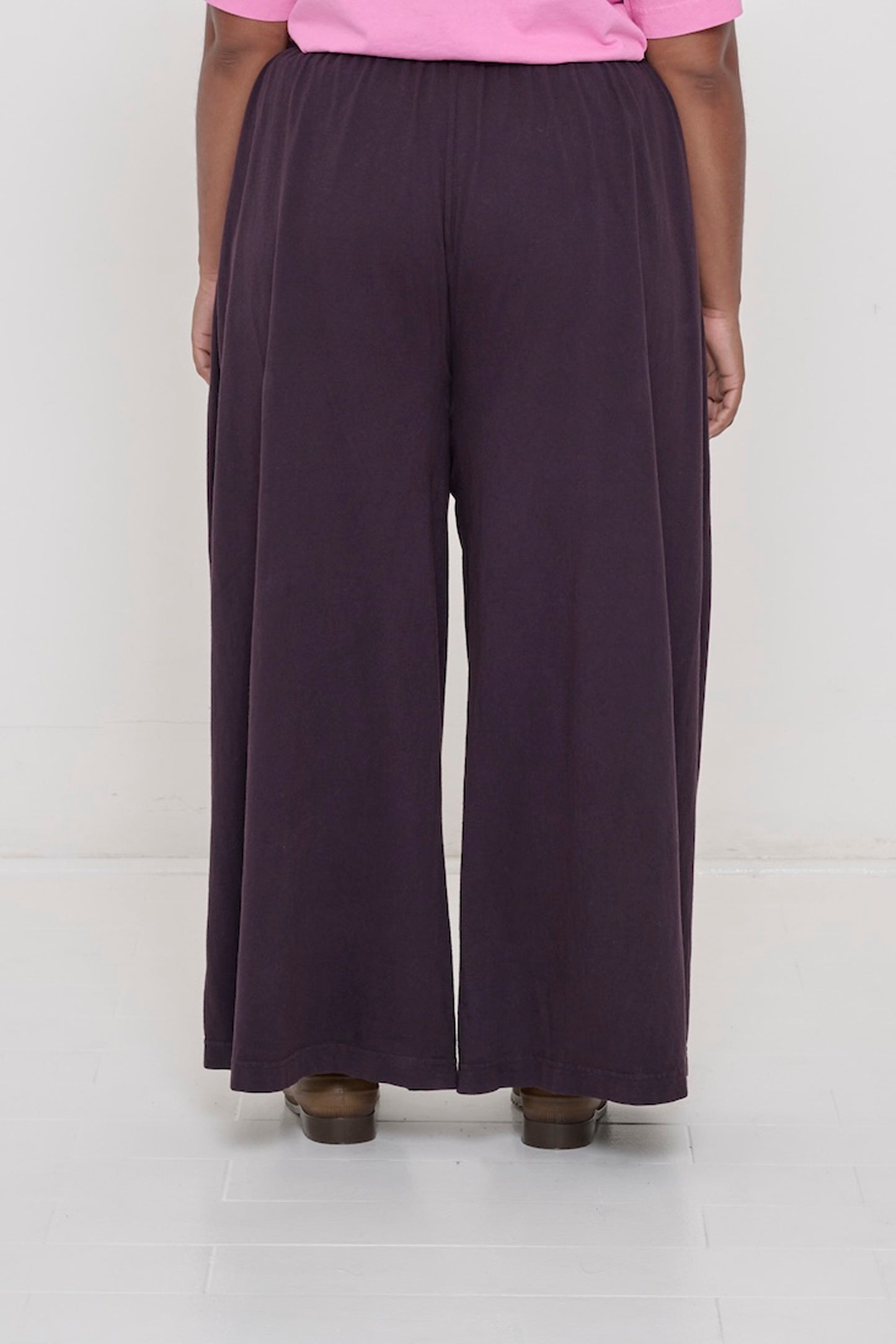 Back view of a person wearing Mulberry Tubular Pants showing flowing vertical fabric folds.