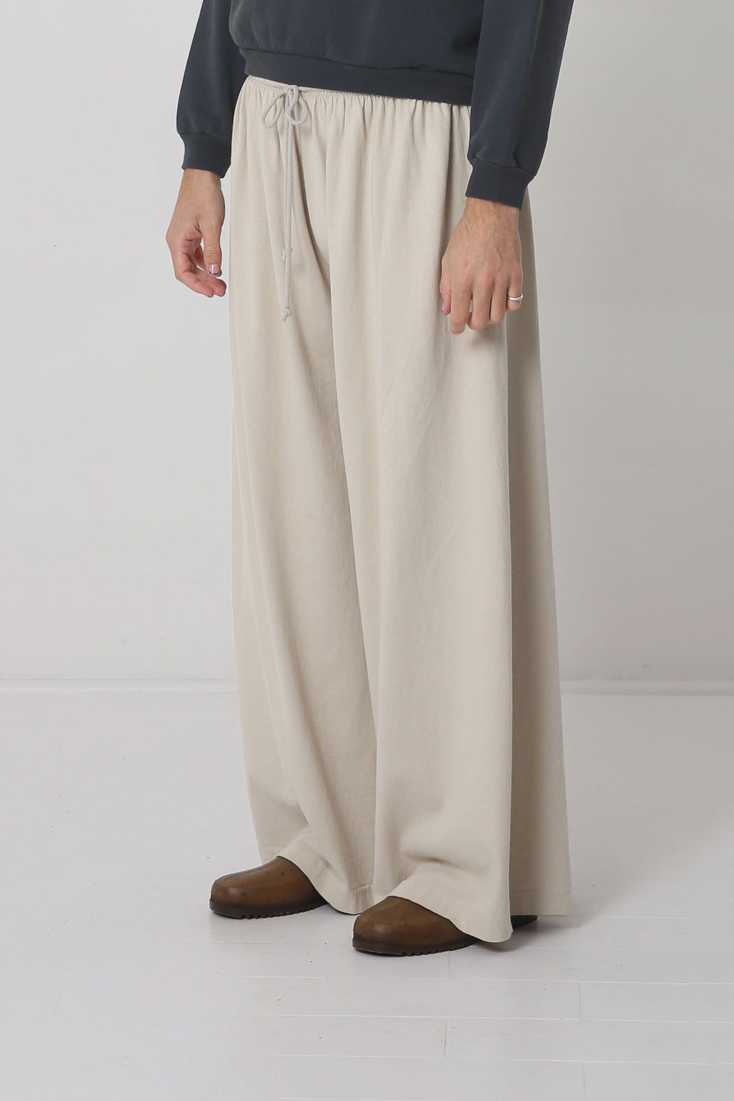 Person facing 45-degrees from the front, showing lack of side seams and flowing wide pant legs.