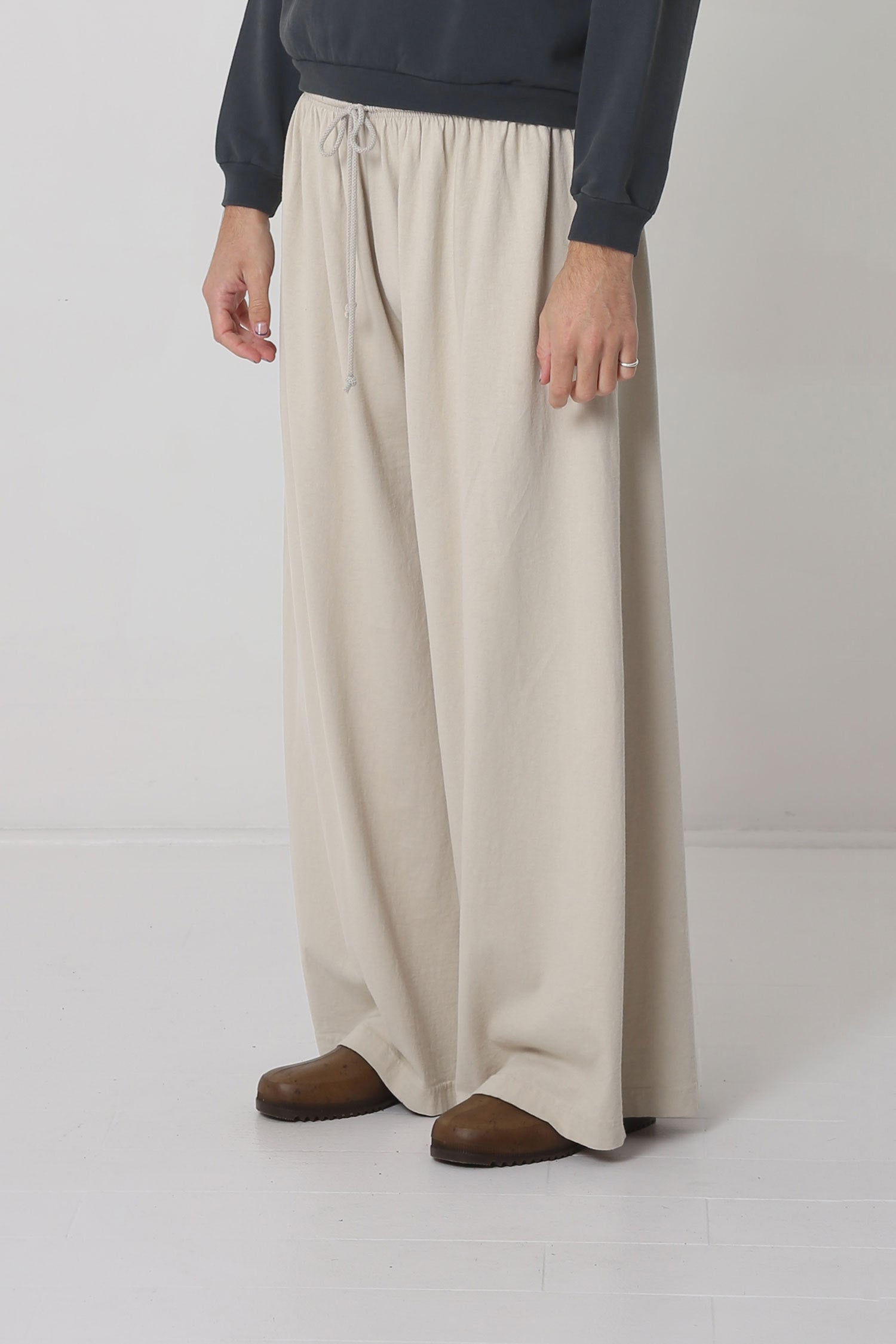 Person facing 45-degrees from the front, showing lack of side seams and flowing wide pant legs.