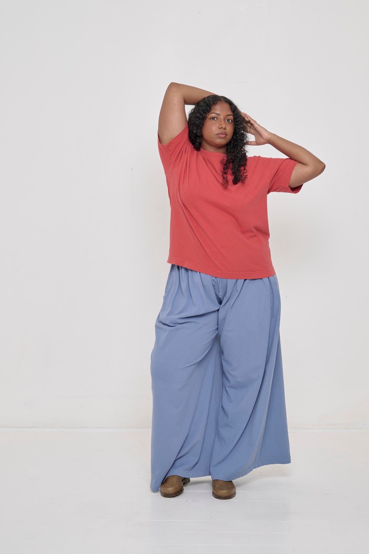 A person wearing Periwinkle Tubular Pants and a Cedar Boxier Trash Tee.
