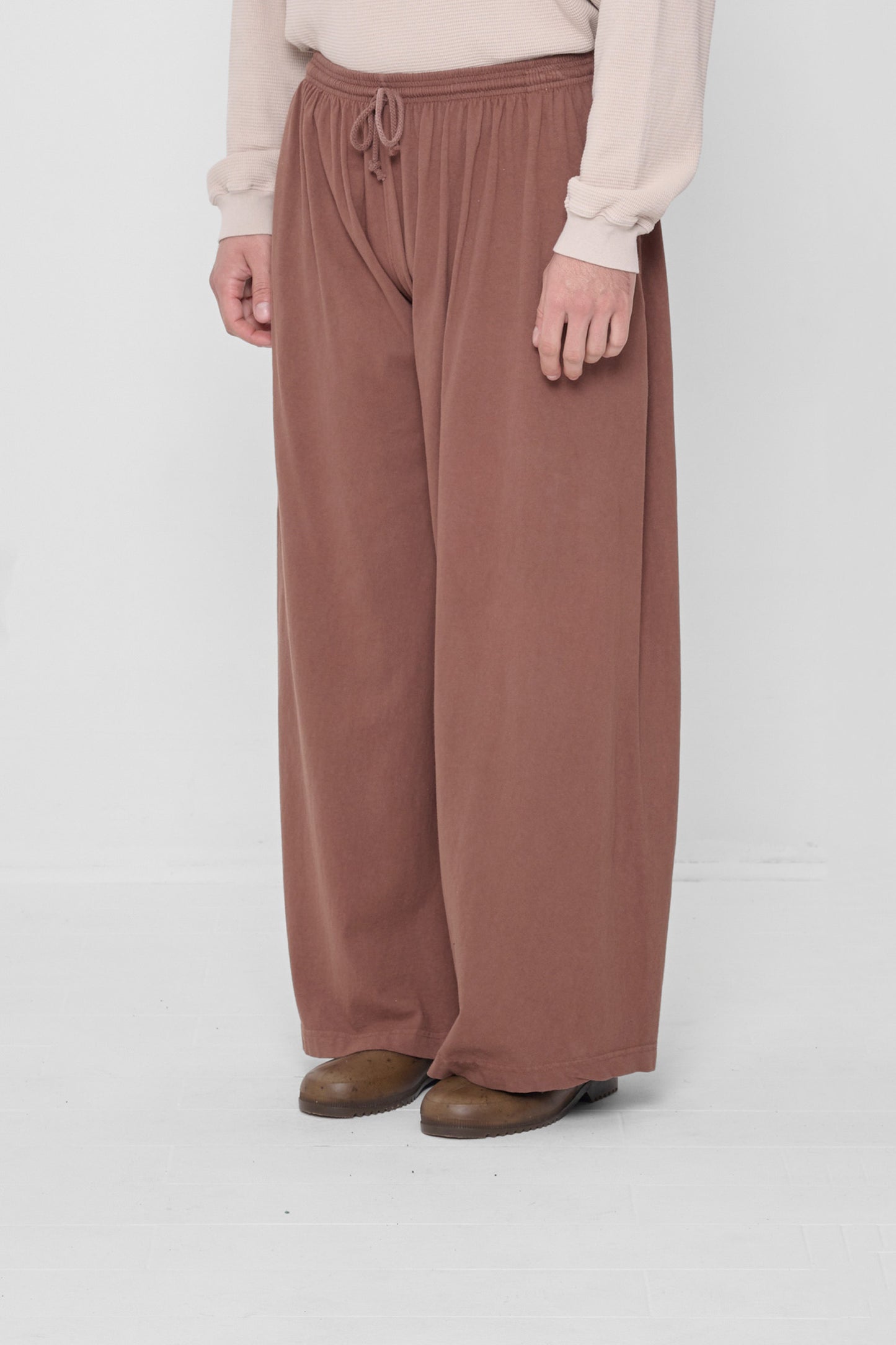 Person facing 45-degrees from the front, showing lack of side seams and flowing wide pant legs.