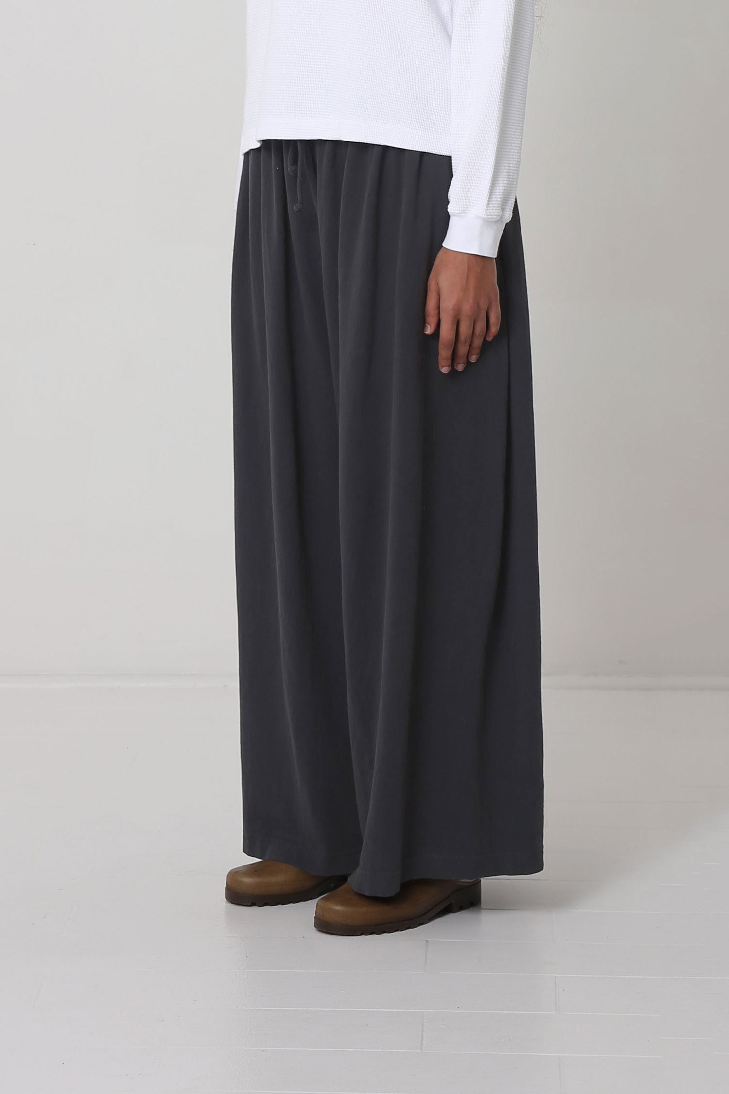 Person facing 45-degrees from the front, showing lack of side seams and flowing wide pant legs.