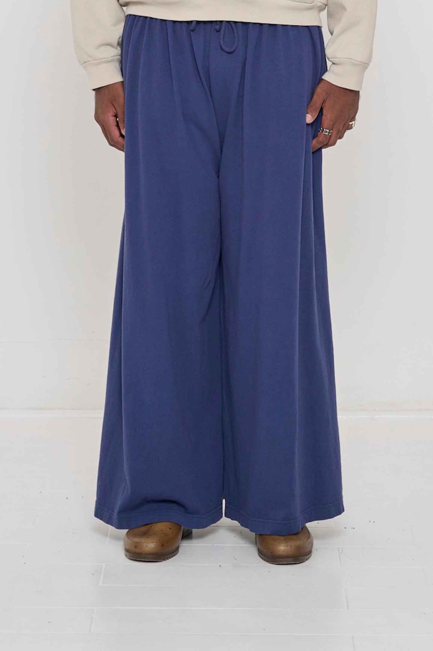Front view of a person in Washed Navy Tubular Pants, featuring elastic waistband, drawcord, relaxed drape.
