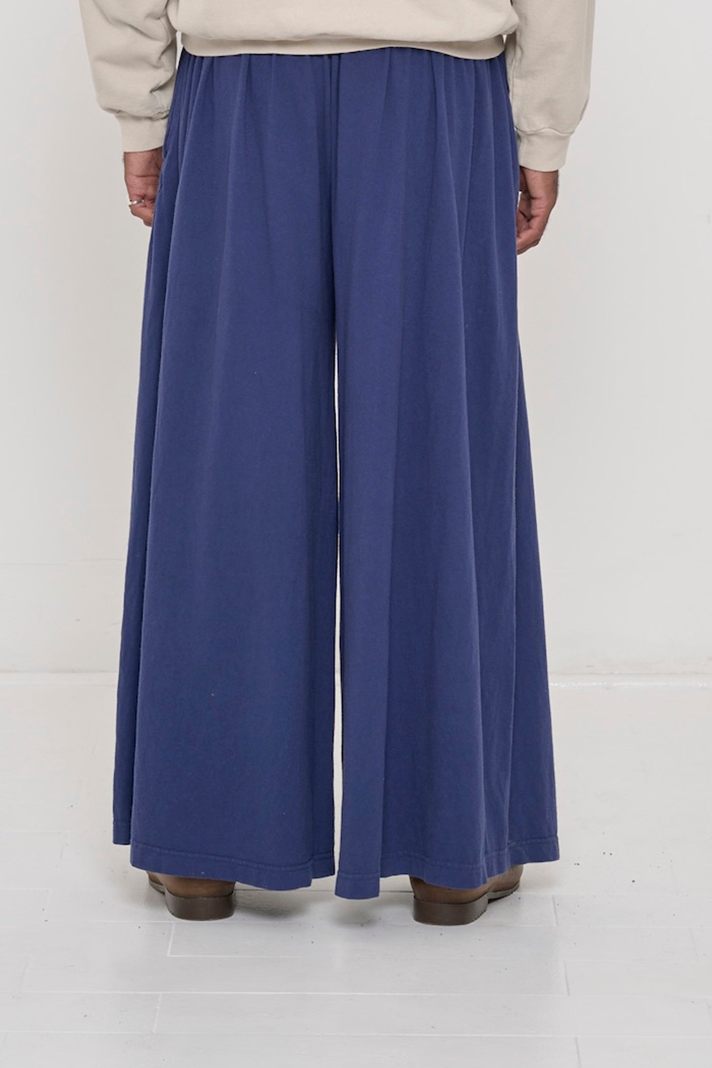 Back view of a person wearing Washed Navy Tubular Pants showing flowing vertical fabric folds.