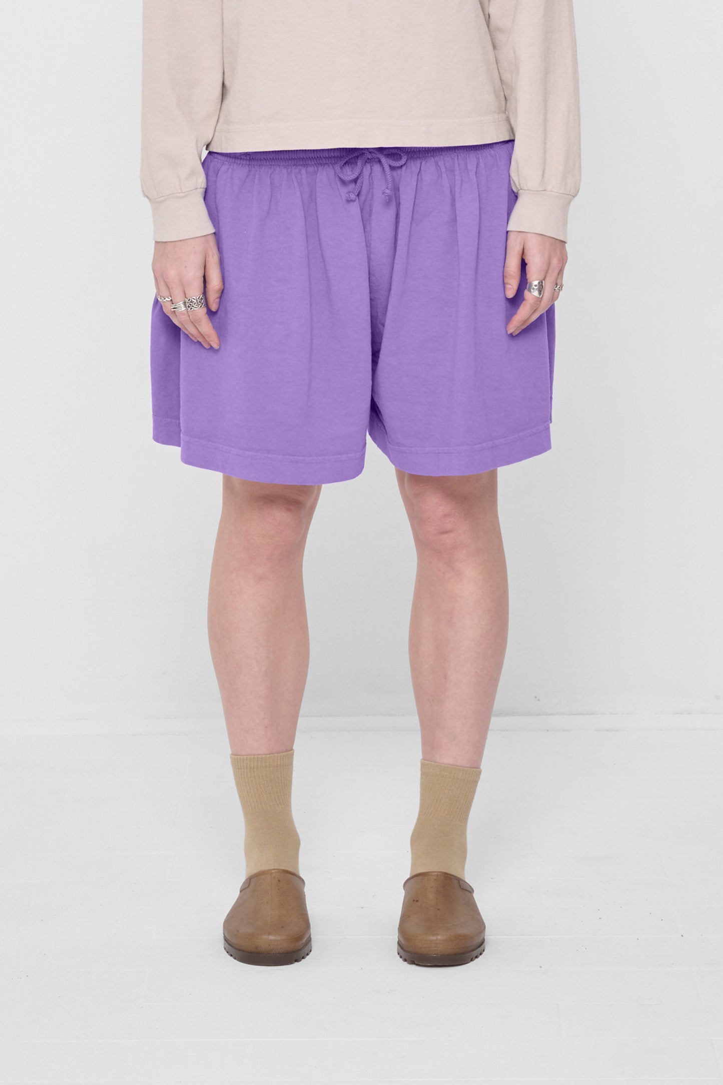 5'6" person in Carpe Diem Tubular Shorts. Front hem hits above the knee worn low on their waist.