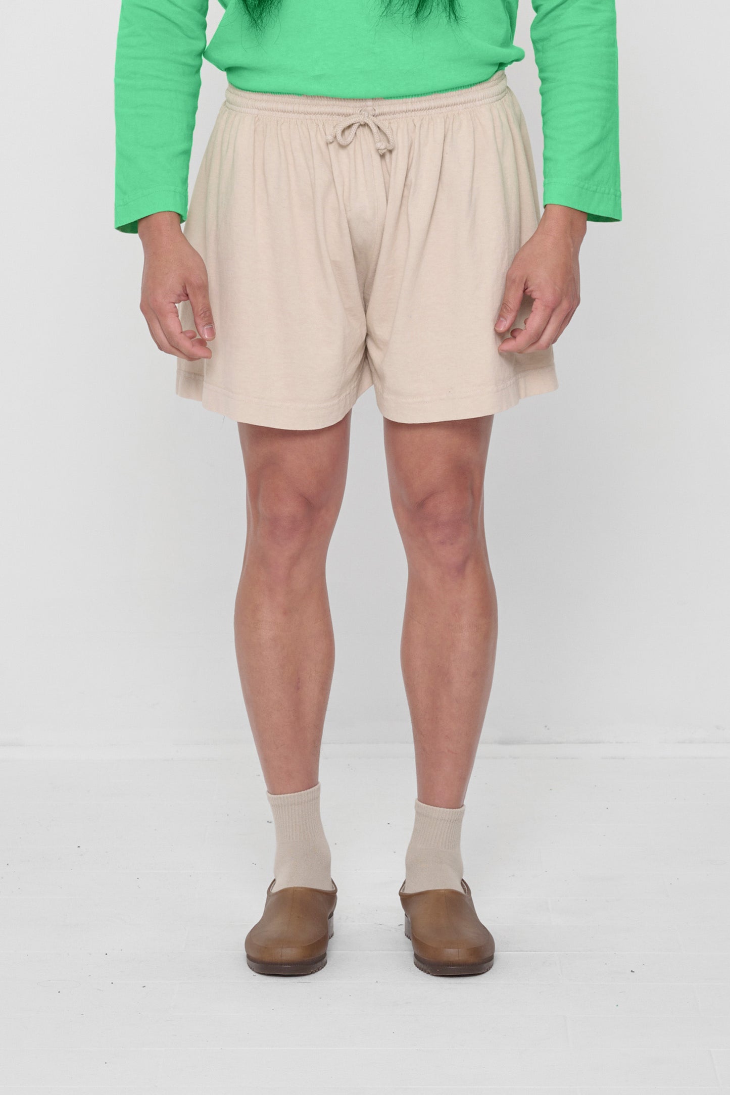 5'11" person in Oat Tubular Shorts. Front hem hits upper mid thigh, and gets shorter at the sides.