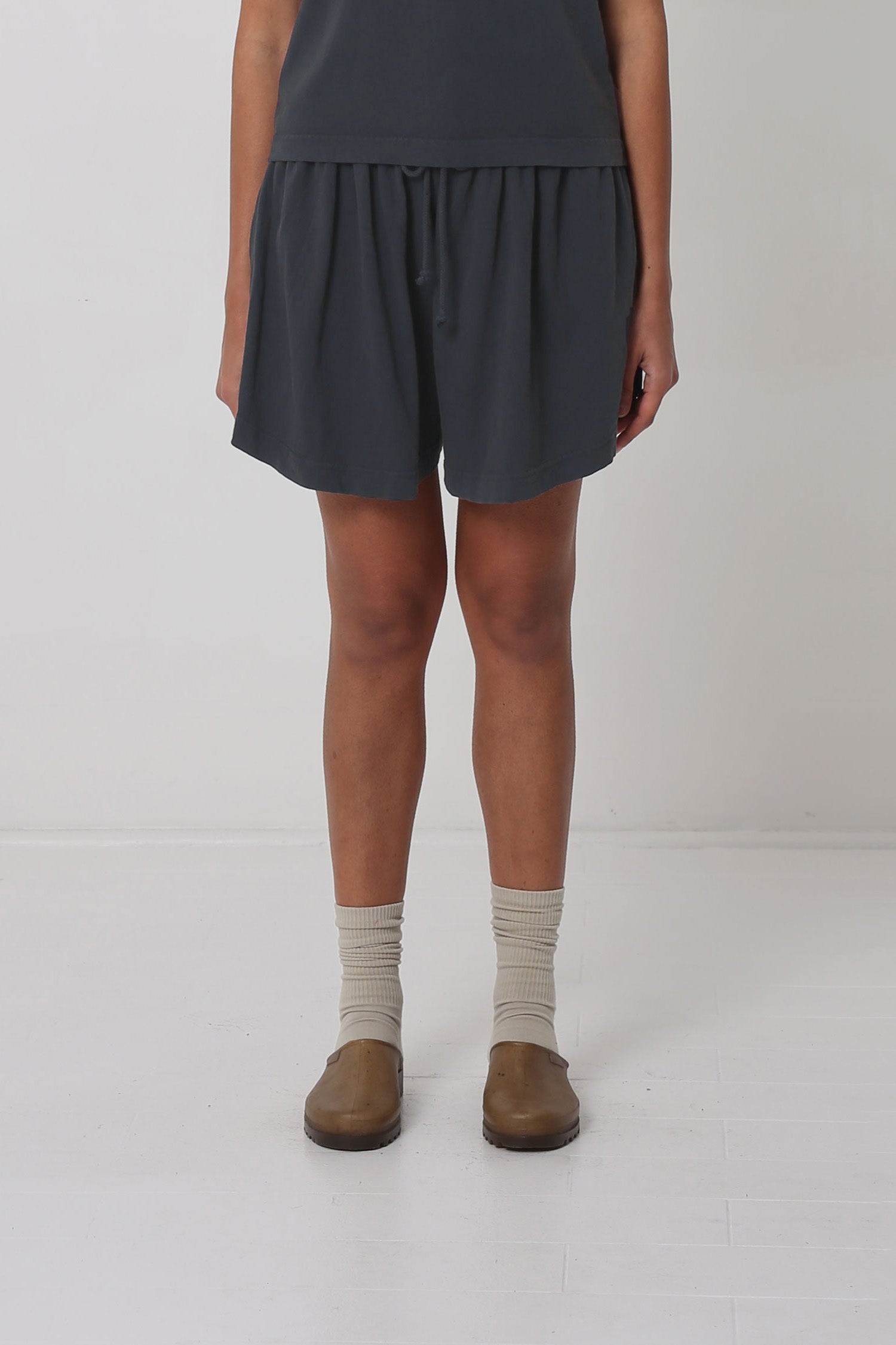 5'10" person in Slate Tubular Shorts. Front hem hits upper mid thigh, and gets shorter at the sides.