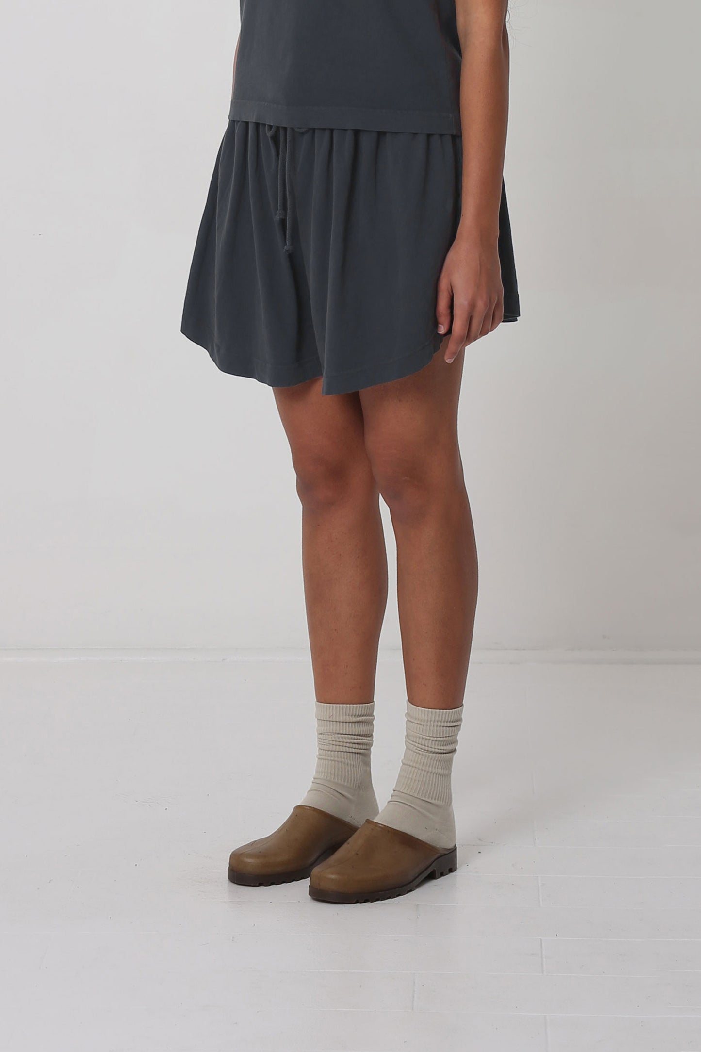 Person facing 45-degrees from the front, showing lack of side seams and side hem that slopes up.