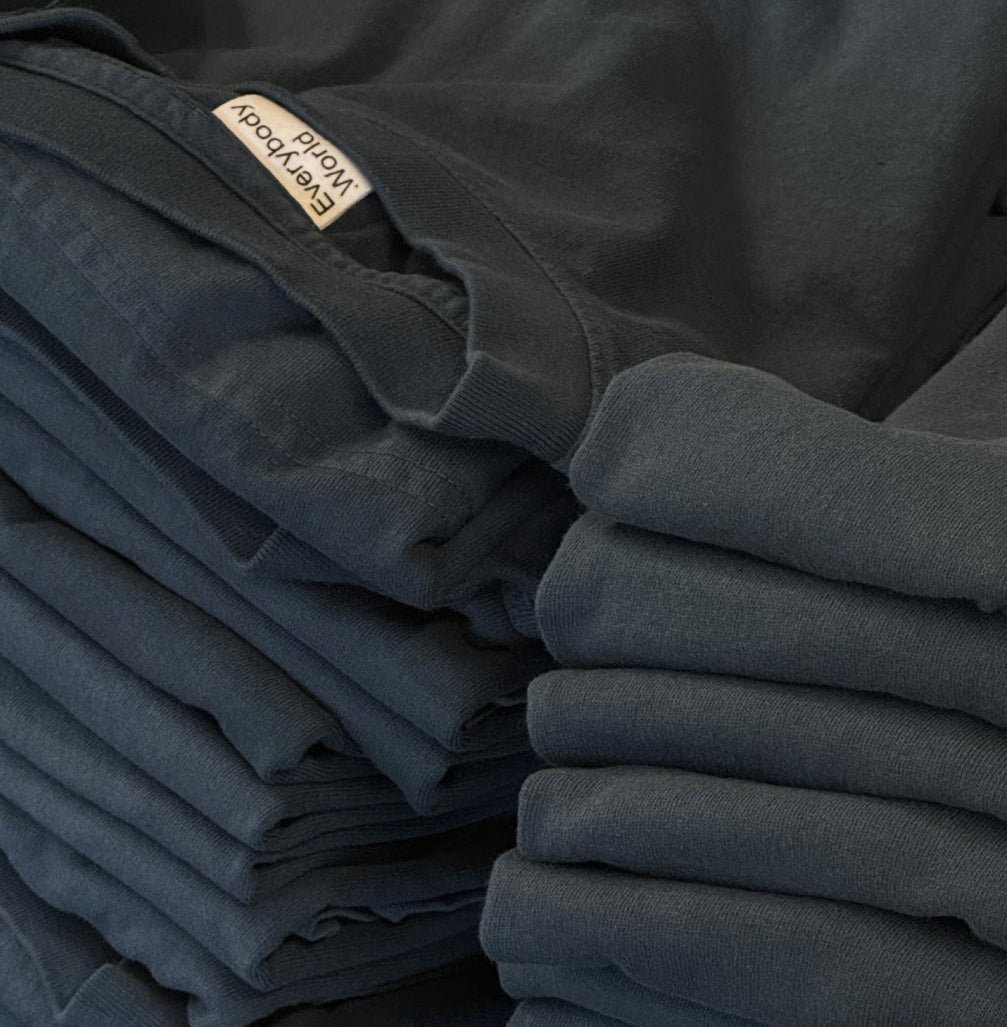 A stack of black T-shirts neatly arranged on a table