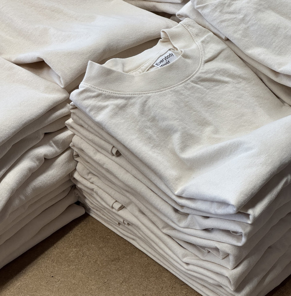 Stacks of neatly folded Scour Trash Tees with labels visible.