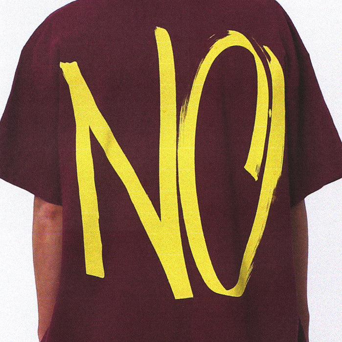 Back of Burgundy T-shirt with large yellow letters 'NO' , designed by artist Carol Bove.